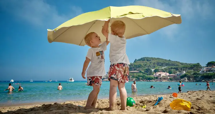 enfants avec crème solaire sur la plage