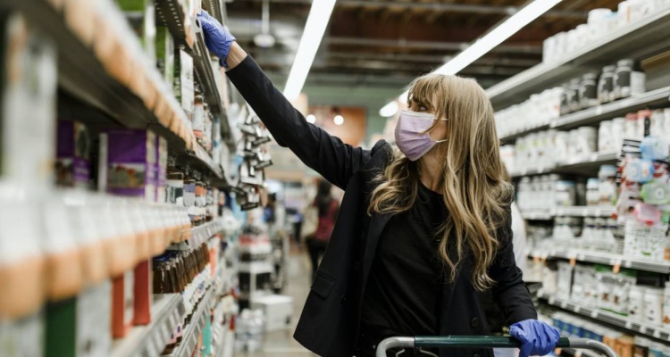 mujer en un supermercado con mascarilla y guantes