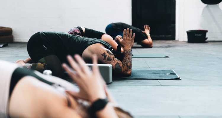 personas haciendo yoga con accesorios