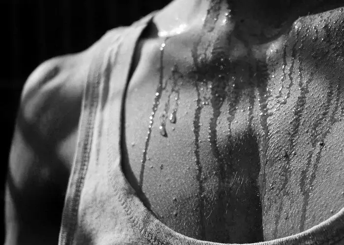 Un hombre sudando avec camiseta de tirantes