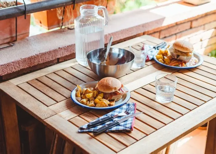 Una mesa en la que hay dos platos con hamburguesas y patatas