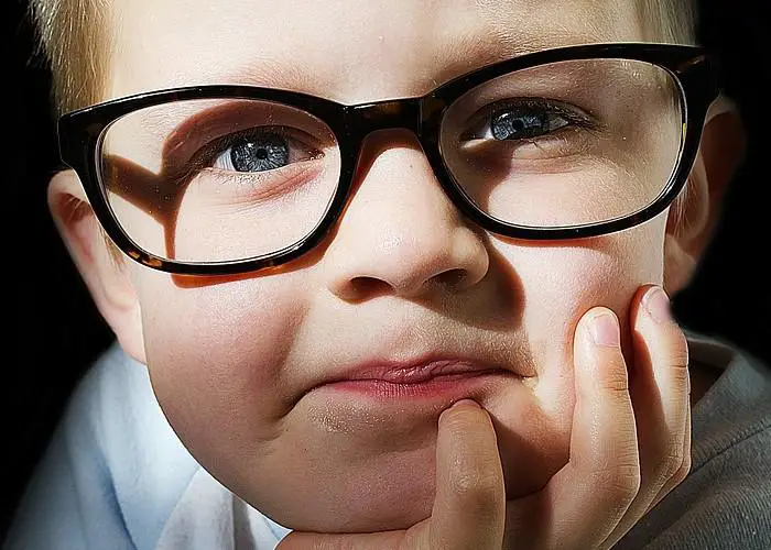 Un niño con ojo vago y gafas negras