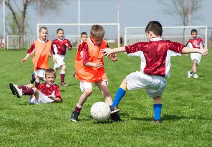 copii jucând la fotbal
