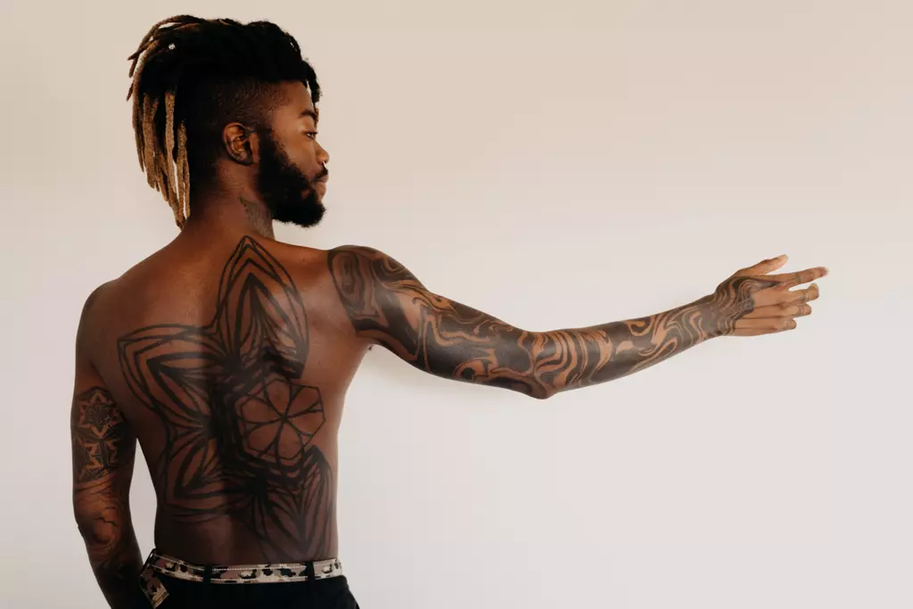 hombre con tatuajes en el cuerpo