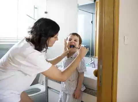 madre lavando los dientes a un niño
