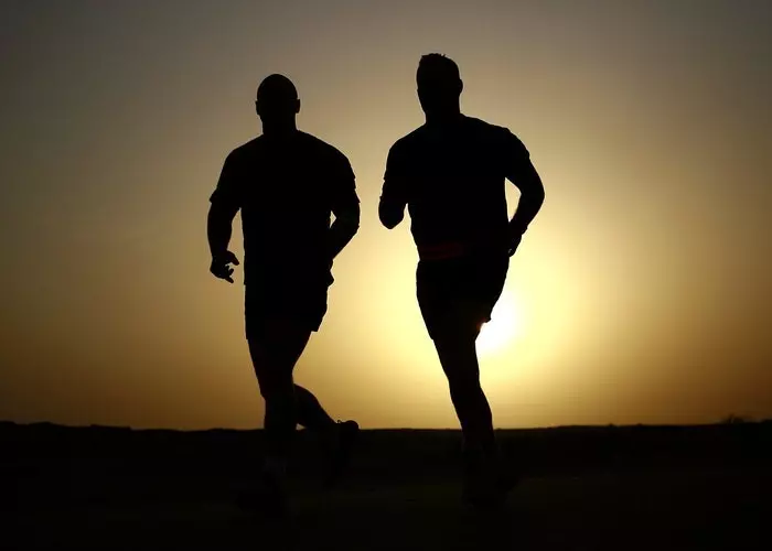 Dos hombres corriendo de noche