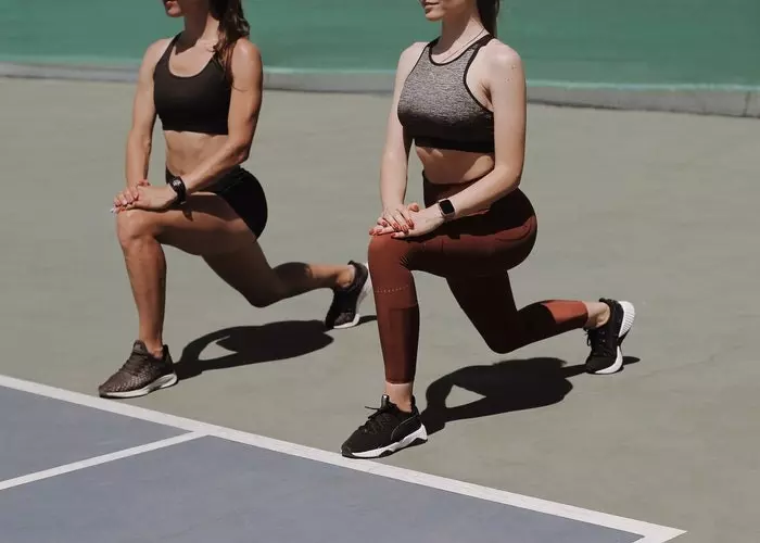 Dos mujeres haciendo zancadas para entrenar glúteos