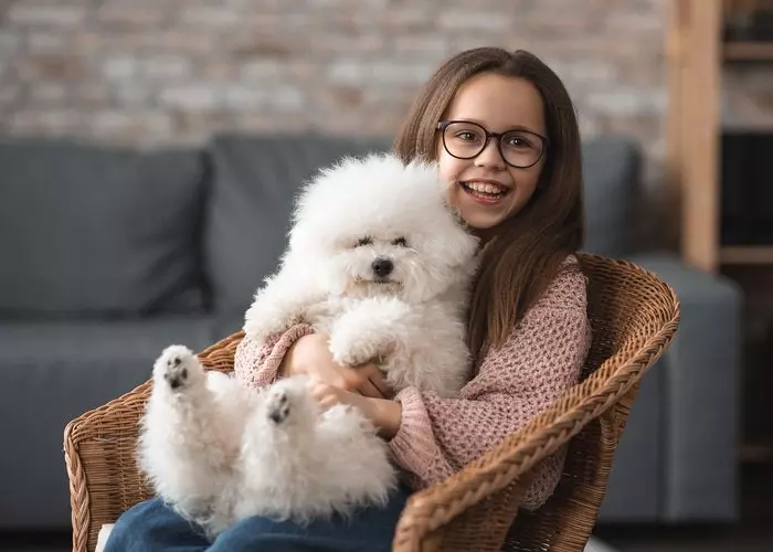 Niña con gafas abrazando a un perro