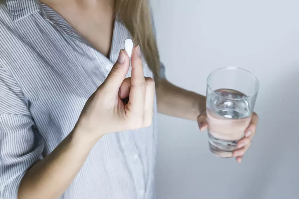 femeie tomando medicacion con agua